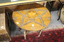 An eastern carved wood circular table on folding stand.