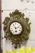 A small ornate brass wall clock.