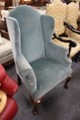 A George III design wing armchair on cabriole legs.