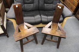 A pair of rustic oak chairs.