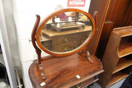A mahogany oval dressing table mirror.