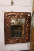 An Arts & Crafts copper framed mirror embossed with fish.