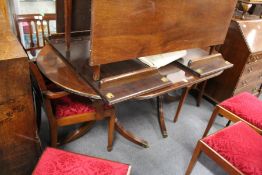 A Regency style mahogany twin pillar dining table with two leaves.