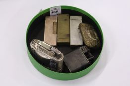 Four Dunhill cigarette lighters, a Ronson Diana table lighter and a decorative vesta case.