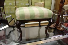 A 19th century mahogany stool on cabriole legs.