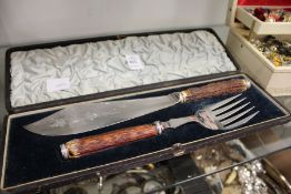 A cased pair of horn handled fish servers.