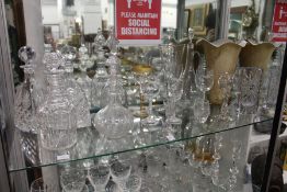 A shelf of cut glassware to include decanters, vases etc.