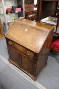 A 19th century oak bureau with drop flap, single drawer above two cupboard doors.
