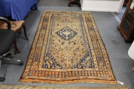 A Persian Shiraz rug, beige ground with stylized decoration.