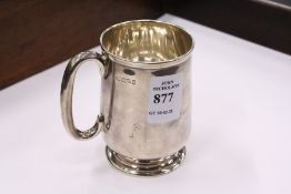 A silver christening mug.