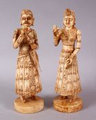 A PAIR OF 19TH CENTURY CARVED INDIAN IVORY FIGURES, one holding a sword, 20cm.
