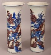 A PAIR OF CHINESE COPPER-RED & UNDERGLAZE-BLUE CYLINDRICAL PORCELAIN VASES, each decorated with a
