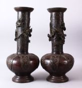 A PAIR OF 18TH CENTURY JAPANESE BRONZE VASES, bulbous shaped and tapering tops with dragons in