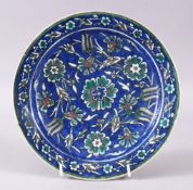 A 19TH/20TH CENTURY PAINTED POTTERY DISH, in the Iznik style, 23cm diameter.