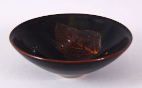 A JIXHOU POTTERY CIRCULAR TEA BOWL, with dark brown glaze, the interior decorated with two leaves,