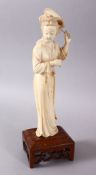A JAPANESE MEIJI PERIOD CARVED IVORY OKIMONO OF A GEISHA GIRL & FAN, stood holding an uchiwa fan