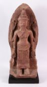 A 12TH CENTURY STYLE CAMBODIAN KHMER STYLE RED SANDSTONE CARVING OF A FOUR ARMED DEITY, 52cms high.
