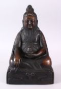 A CHINESE BRONZE CAST FIGURE OF DEITY OR BUDDHA, in a seated position holding a vessel in