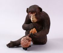 A JAPANESE POTTERY / TERRACOTTA MODEL OF A SEATED MONKEY, the monkey in a seated position holding