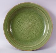 A LARGE AND HEAVY CHINESE CELADON LONGQUAN STYLE MOULDED DRAGON CHARGER, with carved decoration of a