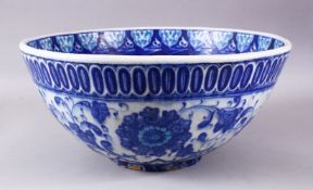 A LARGE 18TH CENTURY IZNIC POTTERY BOWL, with a blue ground decorated with white floral style
