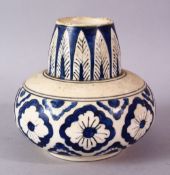 A SMALL ISLAMIC POTTERY VASE, of squat form painted with feather and flower motifs, 11cm high.