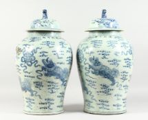 A PAIR OF 20TH CENTURY CHINESE BLUE AND WHITE BALUSTER SHAPE TEMPLE JARS AND COVERS, painted with