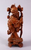 A 19TH CENTURY CARVED WOODEN FIGURE OF SHOU LAO, stood with his head tilted holding his staff and