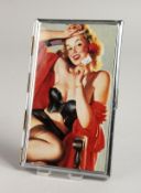 A METAL ENGINE TURNED CIGARETTE CASE, the top with a glamour model, semi-nude holding a card.