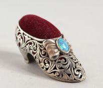 A SILVER SHOE PIN CUSHION.
