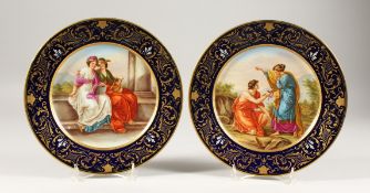 A GOOD PAIR OF 19TH CENTURY PORCELAIN PLATES, rich blue and gilt borders, painted with scenes