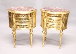 A PAIR OF GILTWOOD OVAL BEDSIDE TABLES with marble tops and three drawers.