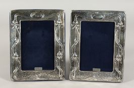 A PAIR OF SILVER UPRIGHT ART NOUVEAU STYLE PHOTOGRAPH FRAMES. 7.5ins x 5.5ins.