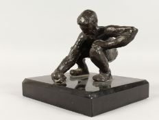 JUGANDO CANICAS (MEXICAN) A BRONZE CROUCHING MAN. Signed, on a black marble base. 5ins high.