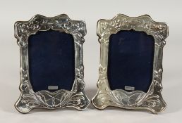 A PAIR OF SILVER UPRIGHT PHOTOGRAPH FRAME with flowers and butterfies. 8.5ins x 5.5ins.