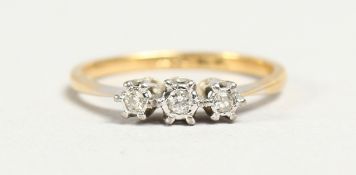 AN 18CT GOLD THREE STONE DIAMOND RING.