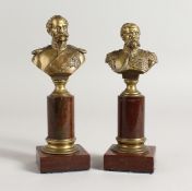 H. GLADENBECK UND SOHN. A SMALL PAIR OF BRONZE BUSTS on marble columns. Signed. 6ins high.