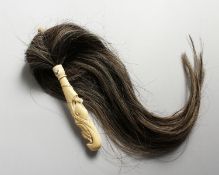 AN ISLAMIC CARVED BONE HANDLED FLY WHISK.