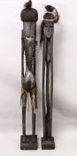 A PAIR OF VERY TALL CARVED WOOD ETHNIC FIGURES. 6ft 1ins high.