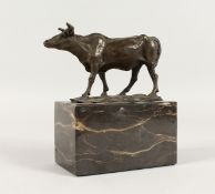 A BRONZE COW on a marble base. 5ins long.