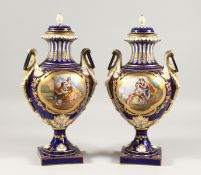 A SUPERB PAIR OF SEVRES TWO-HANDLED VASES AND COVERS, the rich blue ground decorated with gilt and