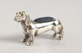 A SILVER DACHSHUND PIN CUSHION.