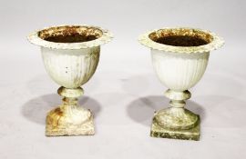A PAIR OF WHITE PAINTED CAST IRON URNS (one AF). 1ft 9ins high.