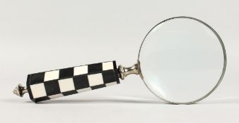 A MAGNIFYING GLASS with chequered handle.