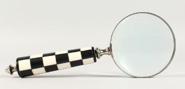 A MAGNIFYING GLASS with chequered handle.
