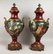 A LARGE PAIR OF PORCELAIN VASES AND COVERS, with metal mounts and bases, painted with reverse