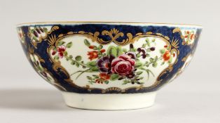 AN 18TH CENTURY WORCESTER BOWL painted with flowers in mirror panel on a blue scale ground.