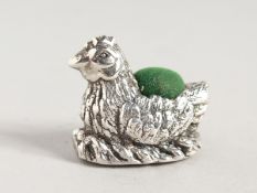 A SILVER CHICKEN PIN CUSHION.