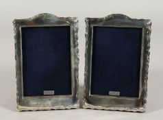 A PAIR OF SILVER UPRIGHT PHOTOGRAPH FRAMES with serpentine tops. 7.5ins x 4.5ins.