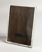 A PLAIN SILVER PHOTOGRAPH FRAME. 9ins x 6.5ins.